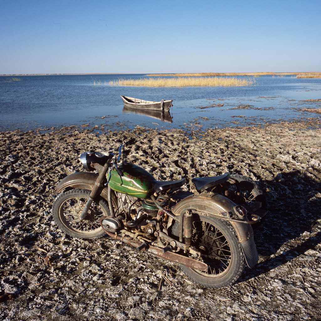 A motorcycle belonging to a fisherman is parked in front of the  Kambash Lake 