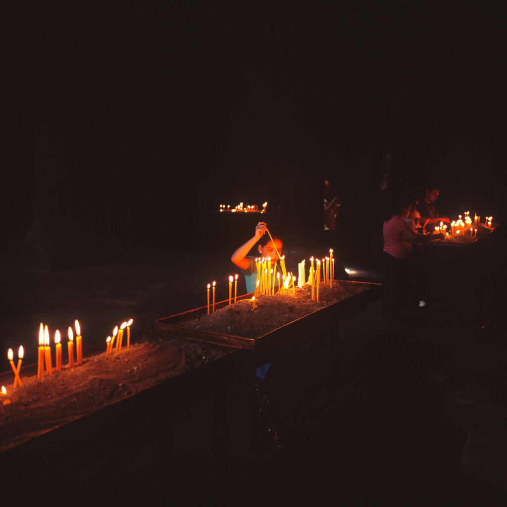 Child lighting candles in Geghard Monastery